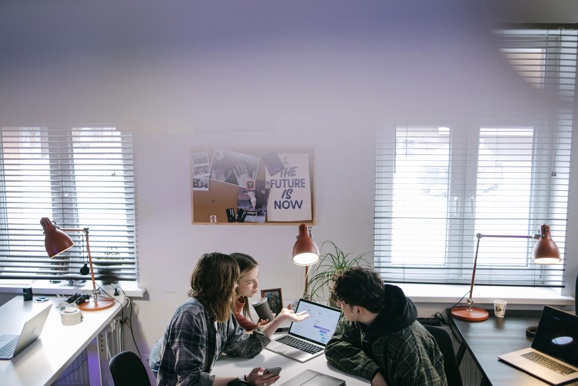 A group of people discussing ideas around laptops in a bright, modern office space — illustrating: How to Choose the Right MSP for Your Business in Central Florida: A Step-by-Step Guide